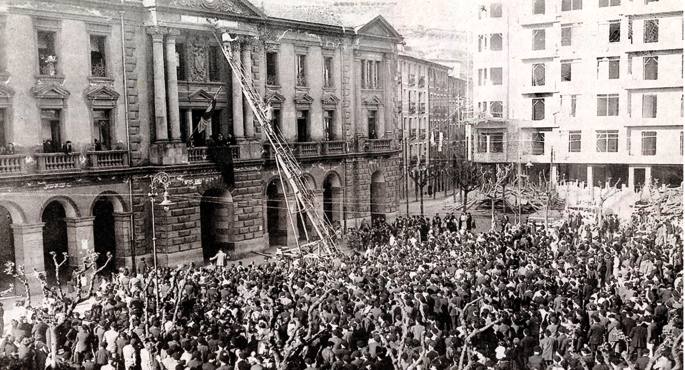 1931ko apirilaren 14a Eibarren, arratsaldez. Udaletxe aurrealdean xafla bat jarri zuten plazaren izena aldatzeko: Alfonso XIII izatetik Errepublikaren Enparantza izatera pasa zen.